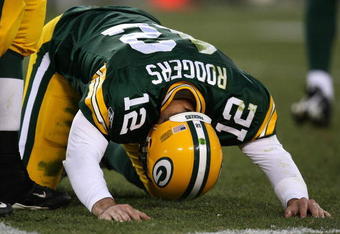 GREEN BAY, WI - NOVEMBER 15: Aaron Rodgers #12 of the Green Bay Packers is slow to get up after being hit during a game against the Dallas Cowboys at Lambeau Field on November 15, 2009 in Green Bay, Wisconsin. The Packers defeated the Cowboys 17-7.  (Photo by Jonathan Daniel/Getty Images)
