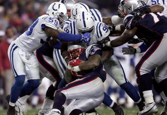 FOXBORO, MA - NOVEMBER 05: Cato June #59 and Robert Mathis #98 of the Indianapolis Colts tackle Corey Dillon #28 of the New England Patriots at Gillette Stadium on November 5, 2006 in Foxboro, Massachusetts.  (Photo by Elsa/Getty Images)