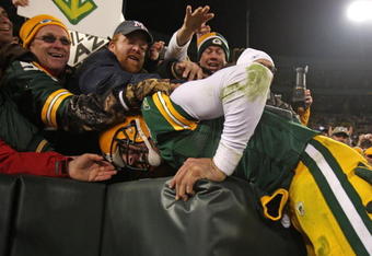 GREEN BAY, WI - NOVEMBER 15: Aaron Rodgers #12 of the Green Bay Packers leaps into the stands after scoring a touchdown against the Dallas Cowboys at Lambeau Field on November 15, 2009 in Green Bay, Wisconsin. The Packers defeated the Cowboys 17-7.  (Photo by Jonathan Daniel/Getty Images)