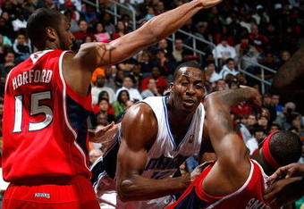 ATLANTA - NOVEMBER 26:  Al Horford #15 of the Atlanta Hawks defends as Josh Smith #5 draws a foul from Dwight Howard #12 of the Orlando Magic at Philips Arena on November 26, 2009 in Atlanta, Georgia.  (Photo by Kevin C. Cox/Getty Images)