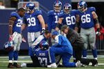 EAST RUTHERFORD, NJ - NOVEMBER 22: Team mates watch on as medical staff attend to Brandon Jacobs #27 of the New York Giants after he injured himself in a tackle against the Atlanta Falcons on November 22, 2009 at Giants Stadium in East Rutherford, New Jersey.  (Photo by Chris McGrath/Getty Images)