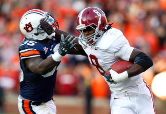 AUBURN, AL - NOVEMBER 27:  Julio Jones #8 of the Alabama Crimson Tide tries to break a tackle by Jonathan Evans #35 of the Auburn Tigers at Jordan-Hare Stadium on November 27, 2009 in Auburn, Alabama.  (Photo by Kevin C. Cox/Getty Images)
