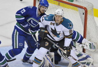 VANCOUVER, CANADA - MARCH 7: Travis Moen #24 of the San Jose Sharks positions in front of the net while being checked by Daniel Sedin #22 of the Vancouver Canucks on March 7, 2009 at General Motors Place in Vancouver, Canada.   (Photo by Nick Didlick/Getty Images)