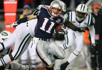 FOXBORO, MA - NOVEMBER 22:  Julian Edelman #11 of the New England Patriots carries the ball for the first down in fourth quarter as Shaun Ellis #92 of the New York Jets makes the tackle on November 22, 2009 at Gillette Stadium in Foxboro, Massachusetts. The Patriots defeated the Jets 31-14.  (Photo by Elsa/Getty Images)
