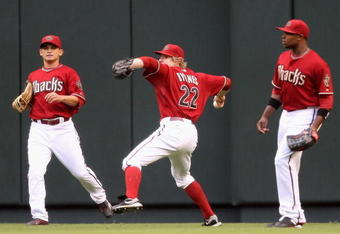 PHOENIX - JUNE 23:  Outfielder Eric Byrnes #22 of the Arizona Diamondbacks fields a triple hit by Michael Young #10 of the Texas Rangers (not pictured) as Gerardo Parra #9 and Justin Upton #10 look on during the first inning of the major league baseball game at Chase Field on June 23, 2009 in Phoenix, Arizona.  (Photo by Christian Petersen/Getty Images)