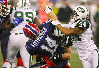 TORONTO - DECEMBER 3: Eric Smith #33 and Marquice Cole #34 of the New York Jets hit quarterback Ryan Fitzpatrick #14 of the Buffalo Bills as he throws the ball at Rogers Centre on December 3, 2009 in Toronto, Canada.  (Photo by Rick Stewart/Getty Images)
