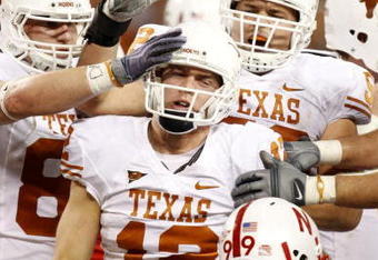 ARLINGTON, TX - DECEMBER 5:  Quarterback Colt McCoy #12 of the Texas Longhorns is congratulated by teammates after his touchdown run in the second quarter against the Nebraska Cornhuskers at Cowboys Stadium on December 5, 2009 in Arlington, Texas. (Photo by Ronald Martinez/Getty Images)