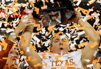 ARLINGTON, TX - DECEMBER 5: Quarterback Colt McCoy #12 of the Texas Longhorns lifts the trophy with head coach Mack Brown after their teams 10-6 victory over the Nebraska Cornhuskers in the game at Cowboys Stadium on December 5, 2009 in Arlington, Texas. (Photo by Ronald Martinez/Getty Images)