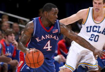 WESTWOOD, CA - DECEMBER 06:  Sherron Collins #4 of the Kansas Jayhawks drives around Michael Roll #20 of the UCLA Bruins on December 6, 2009 at Pauley Pavillion in Westwood, California.  Kansas won 73-61.  (Photo by Stephen Dunn/Getty Images)