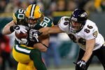 GREEN BAY, WI - DECEMBER 7: Linebacker A.J. Hawk #50 of the Green Bay Packers intercepts the football as tight end Todd Heap #86 of the Baltimore Ravens reaches for the ball at Lambeau Field on December 7, 2009 in Green Bay, Wisconsin. The Packers defeated the Ravens 27-17. (Photo by Scott Boehm/Getty Images)