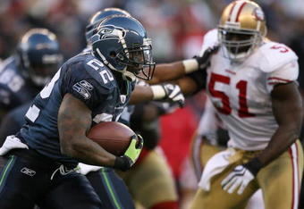 SEATTLE - DECEMBER 06:  Runningback Julius Jones #22 of the Seattle Seahawks rushes against Takeo Spikes #51 of the San Francisco 49ers on December 6, 2009 at Qwest Field in Seattle, Washington. The Seahawks defeated the 49ers 20-17. (Photo by Otto Greule Jr/Getty Images)