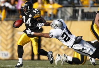 PITTSBURGH - DECEMBER 06:  Rashard Mendenhall #34 of the Pittsburgh Steelers tries to get around the tackle of Michael Huff #24 the Oakland Raiders during a first quarter run on December 6, 2009 at Heinz Field in Pittsburgh, Pennsylvania.  (Photo by Gregory Shamus/Getty Images)