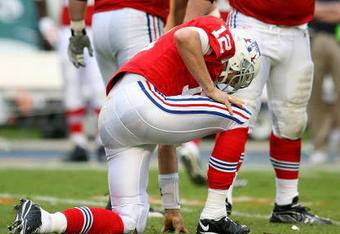 MIAMI - DECEMBER 06:  Quarterback Tom Brady #12 of the New England Patriots is slow to get up after throwing an interception late in the game while being hit by linebacker Cameron Wake #91 of the Miami Dolphins at Land Shark Stadium on December 6, 2009 in Miami, Florida. The Dolphins defeated the Patriots 22-21.  (Photo by Doug Benc/Getty Images)