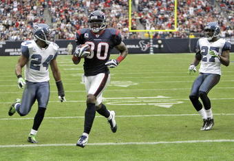 HOUSTON - DECEMBER 13:  Wide receiver Andre Johnson #80 of the Houston Texans scores on a 17-yard touchdown reception in the second quarter against safety Deon Grant #27 and safety Jordan Babineaux #27 of the Seattle Seahawks in the second quarter at Reliant Stadium on December 13, 2009 in Houston, Texas. Houston won 34-7.  (Photo by Bob Levey/Getty Images)