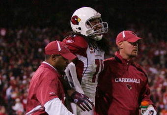 SAN FRANCISCO - DECEMBER 14:  Wide receiver Larry Fitzgerald #11 of the Arizona Cardinals is helped off the field after injuring his knee during their game against the San Francisco 49ers at Candlestick Park on December 14, 2009 in San Francisco, California. (Photo by Ezra Shaw/Getty Images)