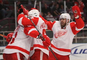 NEW YORK - DECEMBER 06:  Dan Cleary #11 of the Detroit Red Wings is congratulated on his third period goal by teammates Tomas Holmstrom #96 and Henrik Zetterberg #40 against the New York Rangers on December 6, 2009 at Madison Square Garden in New York City.  (Photo by Nick Laham/Getty Images)