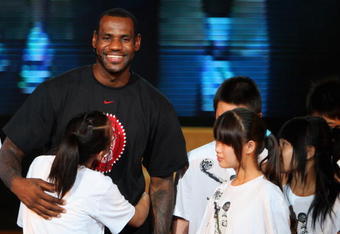 BEIJING - AUGUST 24:  LeBron James of the Cleveland Cavaliers embraces a student from a school for children of migrant workers at a promotional event during a visit to China on August 24, 2009 in Beijing, China.  (Photo by Feng Li/Getty Images)