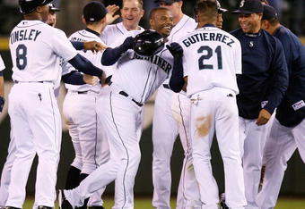 SEATTLE  - AUGUST 12:  Ken Griffey Jr. #24 of the Seattle Mariners is mobbed by teammates after driving in the winning run in the fourteenth inning to defeat the Chicago White Sox 1-0 on August 12, 2009 at Safeco Field in Seattle, Washington. (Photo by Otto Greule Jr/Getty Images)