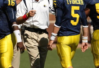 ANN ARBOR, MI - SEPTEMBER 19:  Head coach Rich Rodriguez of the Michigan Wolverines talks with quarterback Tate Forcier #5 during the game with the Eastern Michigan Eagles at Michigan Stadium on September 19, 2009 in Ann Arbor, Michigan.  Michigan won 45-17.  (Photo by Stephen Dunn/Getty Images)