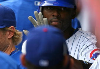 CHICAGO - AUGUST 28: Milton Bradley #21 of the Chicago Cubs receives congratulations in the dugout from teammates after scoring a run in the first inning against the New York Mets on August 28, 2009 at Wrigley Field in Chicago, Illinois. The Cubs defeated the Mets 5-2. (Photo by Jonathan Daniel/Getty Images)