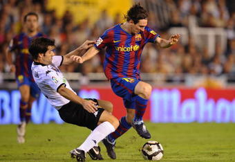 VALENCIA, SPAIN - OCTOBER 17: Lionel Messi (R) of Barcelona is tackled by David Albelda of Valencia during the La Liga Match between Valencia and Barcelona at Estadio Mestalla on October 17, 2009 in Valencia, Spain.  (Photo by Denis Doyle/Getty Images)