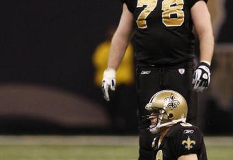 NEW ORLEANS - DECEMBER 19:  Quarterback Drew Brees #9 of the New Orleans Saints sits on the ground after being sacked during their game against the Dallas Cowboys at Louisiana Superdome on December 19, 2009 in New Orleans, Louisiana.  (Photo by Chris Graythen/Getty Images)
