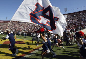 LOS ANGELES - SEPTEMBER 2:  The cheer team of the Auburn Tigers race out onto the field with the team flag bearer leading the way before the game against the USC Trojans on September 2, 2002 at the Los Angeles Coliseum in Los Angeles, California.  USC defeated Auburn 24-17.  (Photo by Stephen Dunn/Getty Images)