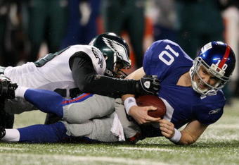 EAST RUTHERFORD, NJ - DECEMBER 13:  Eli Manning #10 of the New York Giants is sacked by a member of the Philadelphia Eagles at Giants Stadium on December 13, 2009 in East Rutherford, New Jersey.  (Photo by Nick Laham/Getty Images)