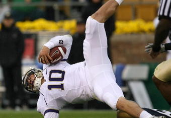 SOUTH BEND, IN - OCTOBER 03: Jake Locker #10 of the Washington Huskies is upended by Brian Smith #58 of the Notre Dame Fighting Irish on October 3, 2009 at Notre Dame Stadium in South Bend, Indiana. (Photo by Jonathan Daniel/Getty Images)