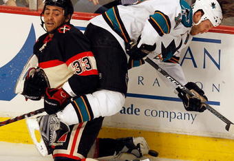 CHICAGO - DECEMBER 22: Joe Thornton #19 of the San Jose Sharks flips over Dustin Byfuglien #33 of the Chicago Blackhawks in an attempt to get the puck at the United Center on December 22, 2009 in Chicago, Illinois. The Sharks defeated the Blackhawks 3-2. (Photo by Jonathan Daniel/Getty Images)
