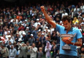 PARIS - JUNE 07:  Roger Federer of Switzerland salutes the fans as he holds the trophy following victory during the Men's Singles Final match against Robin Soderling of Sweden on day fifteen of the French Open at Roland Garros on June 7, 2009 in Paris, France.  (Photo by Ryan Pierse/Getty Images)