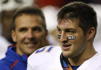 ATLANTA - DECEMBER 5:  Quarterback Tim Tebow #15 (R) and head coach Urban Meyer of the Florida Gators smile during warm ups against the Alabama Crimson Tide during the SEC Championship game at Georgia Dome on December 5, 2009 in Atlanta, Georgia.  (Photo by Chris Graythen/Getty Images)