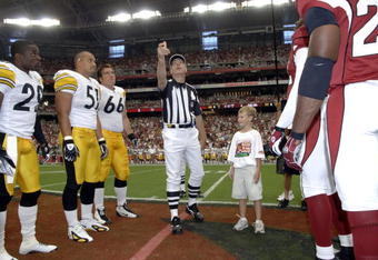 NFL referee Jeff Triplett tosses the coin as the  Arizona Cardinals  host the Pittsburgh Steelers August 12, 2006.  The Cardinals opened a new stadium in Glendale, Arizona and won 21 - 13.  (Photo by Al Messerschmidt/Getty Images)