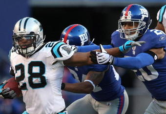 EAST RUTHERFORD, NJ - DECEMBER 27:  Jonathan Stewart #28 of the Carolina Panthers rushes against the New York Giants at Giants Stadium on December 27, 2009 in East Rutherford, New Jersey.  (Photo by Nick Laham/Getty Images)