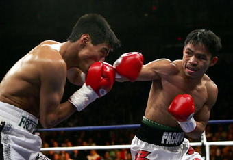 LAS VEGAS - JANUARY 21:  (R-L) Manny Pacquiao of the Phillippines throws a right on Erik Morales of Mexico during their Super Featherweight Championship fight at Thomas & Mack Arena on January 21, 2006 in Las Vegas, Nevada. Pacquiao defeated Morales by a 10th round knockout. (Photo by Jed Jacobsohn/Getty Images)