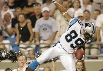 CHARLOTTE, N.C. - AUGUST 19:  Steve Smith #89 of the Carolina Panthers catches a pass in the air as he is grabbed by Will Peterson #24 of the New York Giants during the game on August 19, 2004 at Bank of America Stadium in Charlotte, North Carolina. The Panthers won 27-20. (Photo By Grant Halverson/Getty Images)