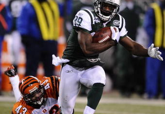 EAST RUTHERFORD, NJ - JANUARY 03:  Jerricho Cotchery #89 of the New York Jets runs the ball against Tom Nelson #43 of the Cincinnati Bengals at Giants Stadium on January 3, 2010 in East Rutherford, New Jersey.  (Photo by Jeff Zelevansky/Getty Images)