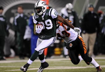 EAST RUTHERFORD, NJ - JANUARY 03:  Jerricho Cotchery #89 of the New York Jets gets a first down against Tom Nelson #43 of the Cincinnati Bengals at Giants Stadium on January 3, 2010 in East Rutherford, New Jersey.  (Photo by Jeff Zelevansky/Getty Images)