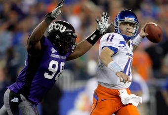 GLENDALE, AZ - JANUARY 04:  Quarterback Kellen Moore #11 of the Boise State Broncos passes the ball in the first half as he is hit by Jerry Hughes #98 of the TCU Horned Frogs during the Tostitos Fiesta Bowl at the Universtity of Phoenix Stadium on January 4, 2010 in Glendale, Arizona.  (Photo by Jamie Squire/Getty Images)