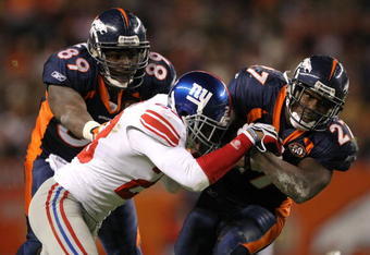 DENVER - NOVEMBER 26:  Knowshon Moreno #27 of the Denver Broncos rushes for a first down before being tackled by Corey Webster #23 of the New York Giants as Daniel Graham #89 of the Broncos blocks during NFL action at Invesco Field at Mile High on November 26, 2009 in Denver, Colorado. The Broncos defeated the Giants 26-6.  (Photo by Doug Pensinger/Getty Images)