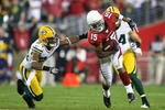 GLENDALE, AZ - JANUARY 10:  Wide receiver Steve Breaston #15 of the Arizona Cardinals runs with the ball past Jarrett Bush #24 of the Green Bay Packers during the 2010 NFC wild-card playoff game at the Universtity of Phoenix Stadium on January 10, 2010 in Glendale, Arizona.  The Cardinals defeated the Packers  51-45 in overtime.  (Photo by Christian Petersen/Getty Images)
