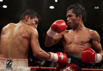 LAS VEGAS - MARCH 19:  Manny Pacquiao (R) of the Philippines throws a right hook at Erik Morales of Mexico during Morales' 15-13 unanimous decision win over Pacquiao during the World Super Featherweight Championship at the MGM Grand Hotel on March 19, 2005 in Las Vegas, Nevada.  (Photo by Donald Miralle/Getty Images)
