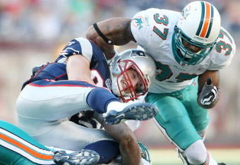 FOXBORO, MA - NOVEMBER 08:  Wes Welker #83 of the New England Patriots is tackled by Yeremiah Bell #37 and Reggie Torbor #53 of the Miami Dolphins on November 8, 2009 at Gillette Stadium in Foxboro, Massachusetts. The Patriots defeated the Dolphins 27-17.  (Photo by Elsa/Getty Images)
