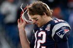 FOXBORO, MA - JANUARY 10:  Tom Brady #12 of the New England Patriots takes off his helmet as he walks to the sideline against the Baltimore Ravens during the 2010 AFC wild-card playoff game at Gillette Stadium on January 10, 2010 in Foxboro, Massachusetts.  (Photo by Elsa/Getty Images)