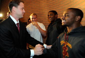 LOS ANGELES, CA - JANUARY 13:  Lane Kiffin (L)  the new college football coach of University of Southern California greets wide receiver Travon Patterson (R) as line backer Devon Kenard (2nd R) and quarterback Matt Barkley look on upon Kiffin's arrival at Heritage Hall on the campus of USC for a news conference on January 13, 2010 in Los Angeles, California.  (Photo by Kevork Djansezian/Getty Images)