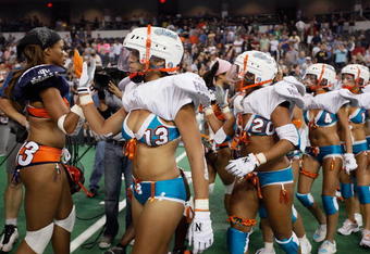 HOFFMAN ESTATES, IL - SEPTEMBER 04:  Members of the Miami Caliente (Blue) and the Chicago Bliss high-five following the Bliss victory in the opening game of the Lingerie Football League (LFL) at the Sears Centre Arena September 4, 2009 in Hoffman Estates, Illinois. The LFL is a female football league with ten teams that compete in seven-on-seven full-contact American football, with players dressed in sports bras and short shorts.  (Photo by Scott Olson/Getty Images)