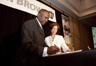 OAKLAND, CA - JULY 18:  Tim Brown signs a one day contract with the Oakland Raiders as Raiders CEO Amy Trask looks on during a press conference at the Grand Ballroom of the Oakland Airport Hilton on July 18, 2005 in Oakland, California. Brown announced his retirement from professional football.  (Photo by David Paul Morris/Getty Images)