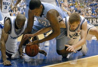 DURHAM, NC - FEBRUARY 07:  DeMarcus Nelson #21, left, and Greg Paulus #3, right, of the Duke University Blue Devils battle Deon Thompson #21 of the North Carolina Tar Heels for a loose ball during their game on February 7, 2007 at Cameron Indoor Stadium in Durham, North Carolina.  (Photo by Grant Halverson/Getty Images)