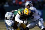 GREEN BAY, WI - DECEMBER 28: James Jones #89 of the Green Bay Packers is tackled by Ernie Sims #50 and Ramzee Robinson #38 of the Detroit Lions on December 28, 2008 at Lambeau Field in Green Bay, Wisconsin. The Packers defeated the Lions 31-21. (Photo by Jonathan Daniel/Getty Images)