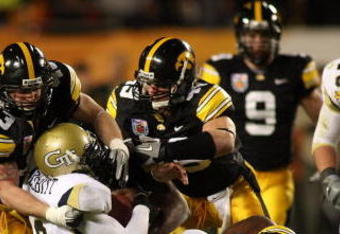 MIAMI GARDENS, FL - JANUARY 05:  Josh Nesbitt #9 of the Georgia Tech Yellow Jackets is bought down by Pat Angerer #43, A.J. Edds #49 and Adrian Clayborn #94 of the Iowa Hawkeyes during the FedEx Orange Bowl at Land Shark Stadium on January 5, 2010 in Miami Gardens, Florida.  (Photo by Marc Serota/Getty Images)